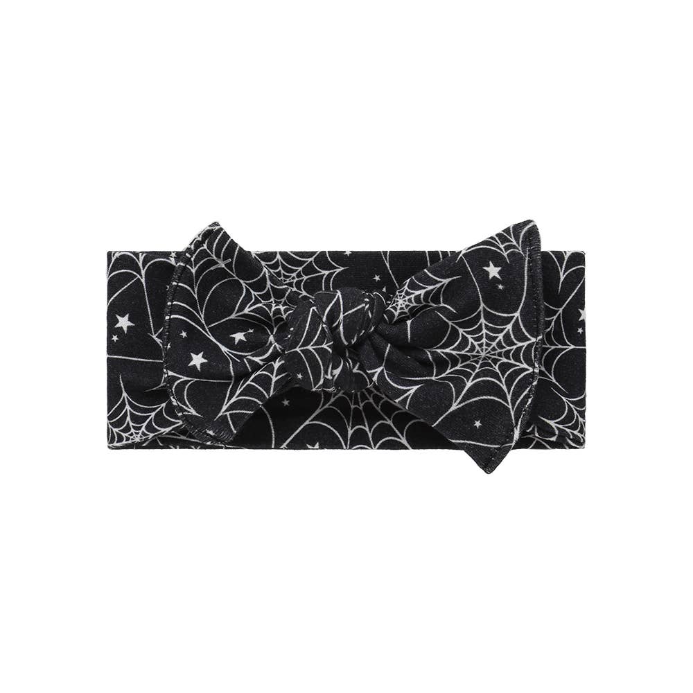 Adjustable black baby headband featuring a white cobweb and star print with a soft cotton tie-knot design.