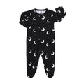 Black cotton baby sleepsuit with white moon and star print, front poppers, and integrated mittens, size 6-12 months.