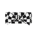Soft cotton baby headband with a black and white checkerboard print and a stylish front knot detail.